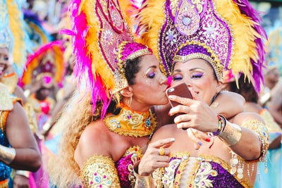 两个女人狂欢舞蹈姿势有问题作为一个亲吻其他的脸颊。
